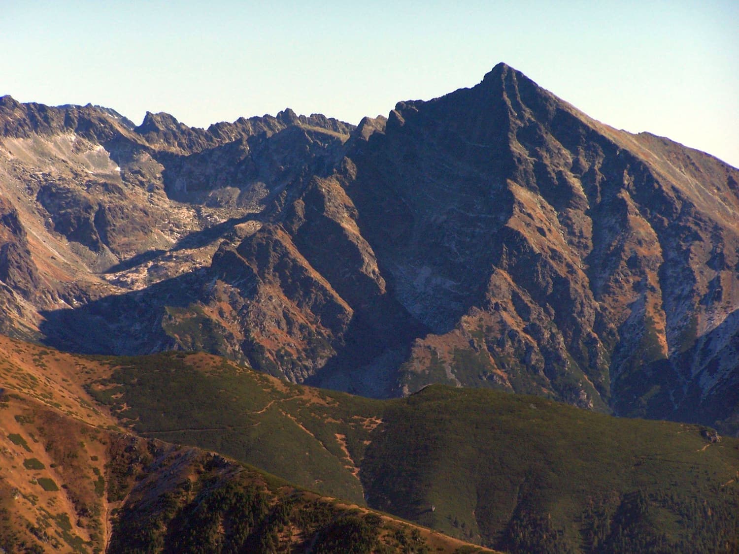 The hooked summit pyramid of Kriváň rising above autumn-coloured slopes